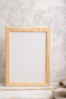 Beyaz ahşap çerçeve, gri beton arka planda keten tekstil. Boş, dikey yönelim, natürmort yaşam, kopyalama alanı.