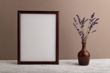 Kahverengi ahşap çerçeve modeli ve bej kağıt arka planda seramik vazoda lavanta. Boş, dikey yönelim, natürmort yaşam, kopyalama alanı.