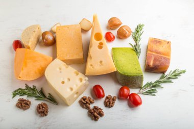 Beyaz ahşap arka planda biberiyeli ve domatesli farklı peynir çeşitleri. Yan görünüm, kapat.