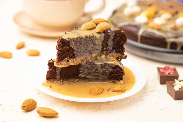 Pedaços Bolo Chocolate Brownie Com Creme Caramelo Amêndoas Fundo Concreto — Fotografia de Stock