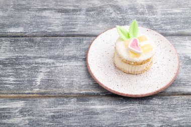 Sütlü, hindistan cevizi kremalı ve gri ahşap kaplamalı pasta. Yan görünüm, kopyala boşluk, kapat.