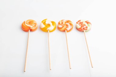 Beyaz arka planda dört lolipop şekeri var. Yaklaş, kenar görünüm.
