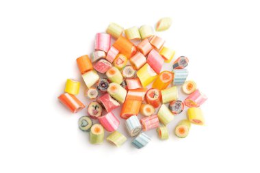 Beyaz arka planda izole edilmiş bir yığın çok renkli karamel şekeri. Yaklaş, üstten bak, düz yat..