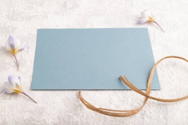 Gri beton arka planda bahar kar tanesi çiçekleri olan mavi kağıt maketi. Boş, kartvizit, yan görüş, fotokopi alanı, natürmort hayat. bahar konsepti.