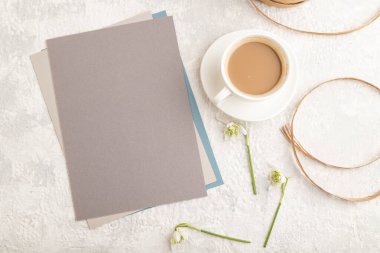 Bahar kardelen galanthus çiçekleri ve gri beton arka planda bir fincan kahve ile gri kağıt maketi. Boş, kartvizit, üst manzara, düz yatak, fotokopi alanı, natürmort hayat. bahar konsepti, kapat.