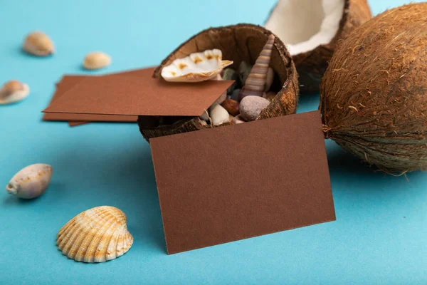 ブルーパステルの背景にココナッツや貝殻と茶色の紙の名刺 サイドビュー スペースをコピーします 健康的な食べ物 休暇の概念 — ストック写真