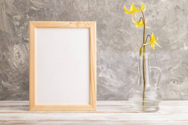 Sarı alabalık zambaklı ahşap çerçeve ya da gri beton arka planda cam camlı köpek dişli mor çiçekler. Yan görünüm, kopyalama alanı, modelleme, şablon, bahar, yaz minimalizmi kavramı.