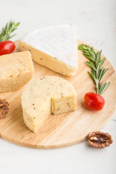 Cheddar Und Verschiedene Käsesorten Mit Rosmarin Und Tomaten Auf Holzbrett — Stockfoto