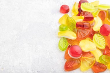 Gri beton arka planda çeşitli meyve jölesi şekerlemeleri. Yan görünüm, boşluk kopyala.