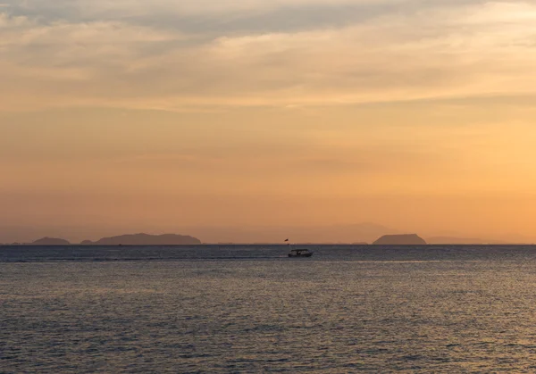 Sonnenuntergang über dem Meer mit kleinem Boot am Horizont — Stockfoto