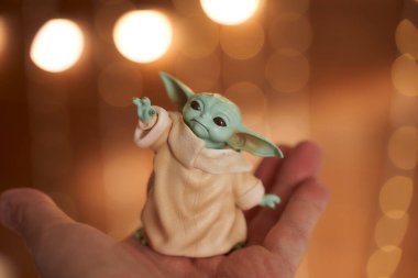 Kasım 2020: Bebek Yoda 'nın görüntüsü, bir aksiyon figürü, hazırda bekliyor. Noel arkaplan efekti. Makro efekt fotoğrafı.