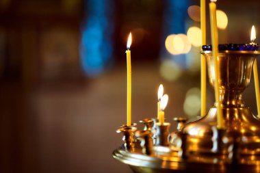 Eski kilisede birçok sarı mum duruyor. Hıristiyanlık. Yanan mum. Makro efekt fotoğrafı. Yakın plan..