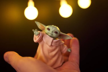 Kasım 2020: Bebek Yoda 'nın görüntüsü, bir aksiyon figürü, hazırda bekliyor. Noel arkaplan efekti. Makro efekt fotoğrafı.