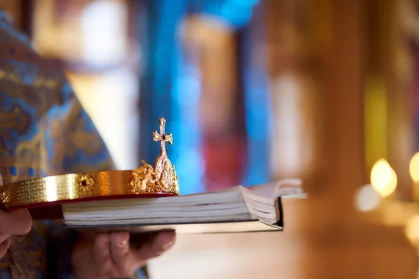 Los sacerdotes sostienen la corona sagrada en la boda en la iglesia cristiana — Foto de Stock