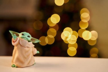2020 Aralık 'ında, bebek Yoda, beyaz masada duran aksiyon figürleri. Noel arkaplan efekti. Makro efekt fotoğrafı.