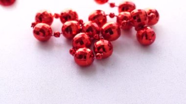 Kırmızı boncuklar beyaz arka plana düşer.