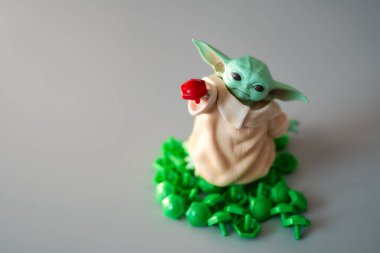 2021 Mart 'ında, oyuncak bebek Yoda' nın görüntüsü yeşil plastik düğmelere basıldı. Gri arka plan. Yüksek kalite fotoğraf