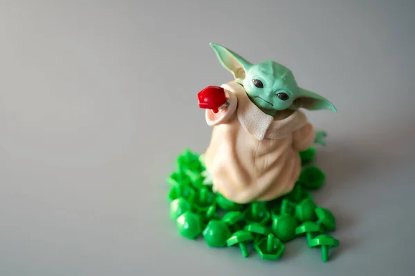 2021 Mart 'ında, oyuncak bebek Yoda' nın görüntüsü yeşil plastik düğmelere basıldı. Gri arka plan. Yüksek kalite fotoğraf