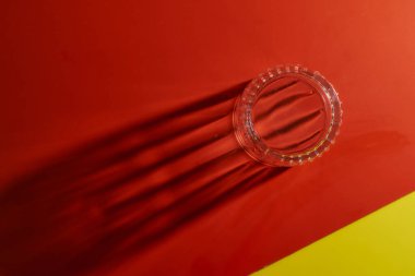 Stacked glasse take away beautiful long shadows on red and yellow backgrounds