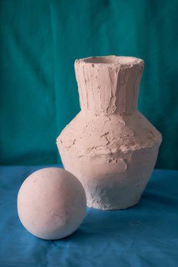 Basit, sakin bir hayat. Mavi arka planda alçı vazo ve top. Yüksek kalite fotoğraf