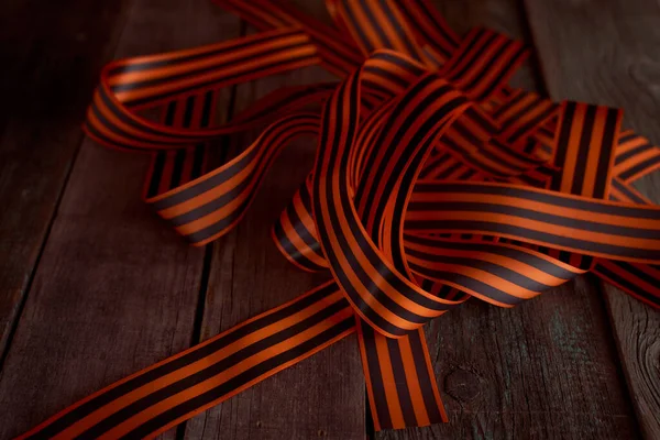 木製の背景に黒オレンジ色のセントジョージリボン 高品質の写真 — ストック写真