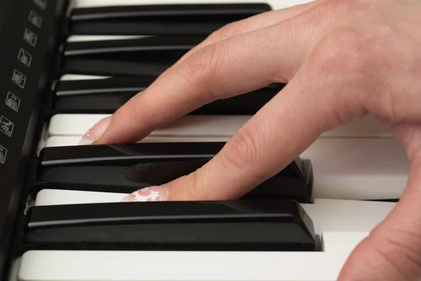 Mulher mão tocando um sintetizador de teclado controlador MIDI de perto — Fotografia de Stock