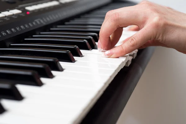 Mulher mão tocando um sintetizador de teclado controlador MIDI de perto — Fotografia de Stock