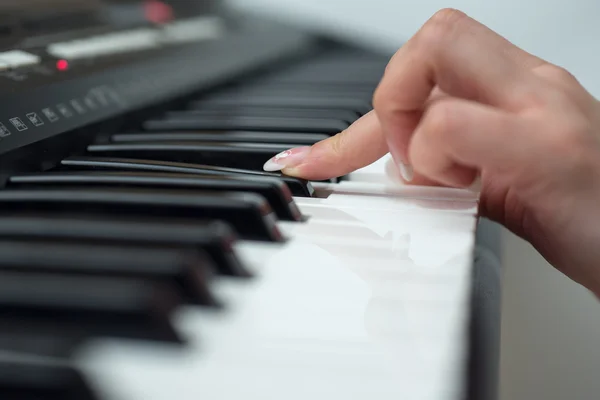 Mulher mão tocando um sintetizador de teclado controlador MIDI de perto — Fotografia de Stock