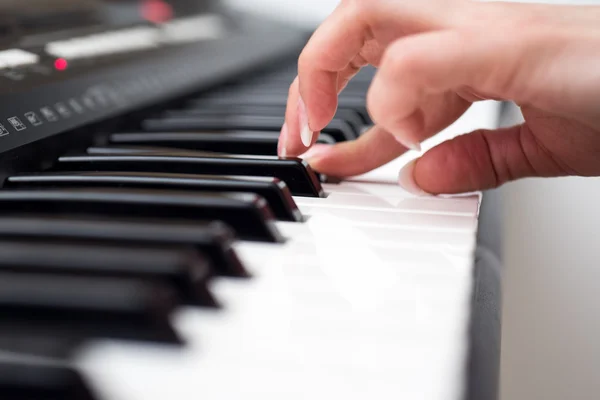 Mulher mão tocando um sintetizador de teclado controlador MIDI de perto — Fotografia de Stock