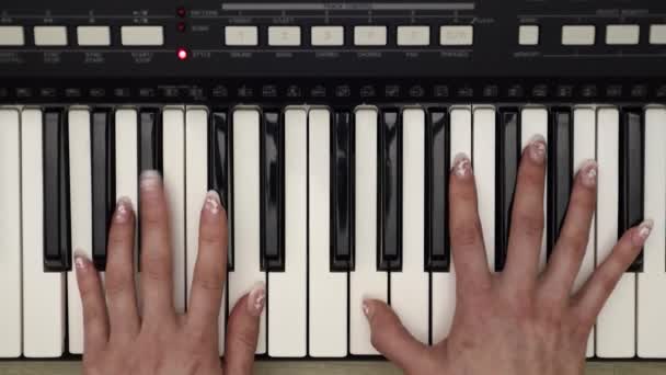 Mãos de mulher jogando no sintetizador, vista superior de perto — Vídeo de Stock