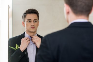 aynaya bakarak bir sandalyede oturan işadamı