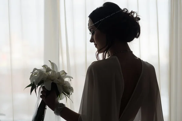 Силует красивої нареченої, що стоїть біля вікна — стокове фото