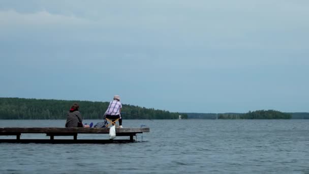 Pessoas e recreação familiar, homem sênior e mulheres pescando juntos no lago — Vídeo de Stock