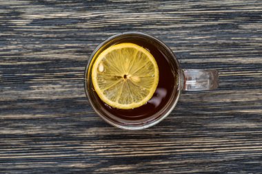 Ahşap masa üzerinde limonlu çay fincan