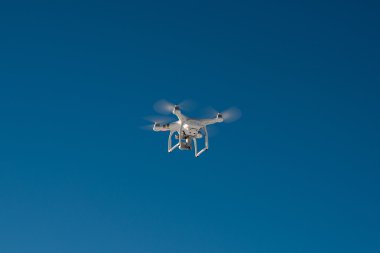 Mavi gökyüzünde uçan ile beyaz dron dört helikopter