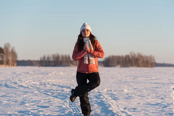 Woman sitting in a yoga position on frozen lake snow — Stock Photo, Image