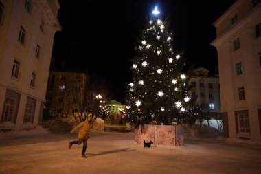 Şehirde gece vakti parlak ışıkları olan Noel ağacı.
