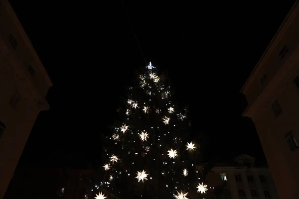 Árbol de Navidad con luces brillantes por la noche en la ciudad —  Fotos de Stock