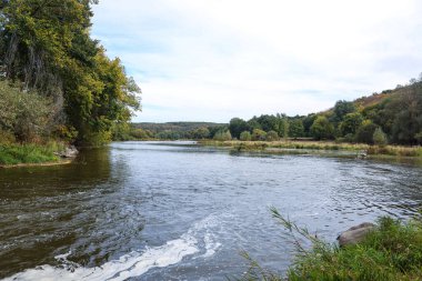 Güzel, hızlı akan bir nehir. Ağaçlar arasında oynak su. Kırsal alan