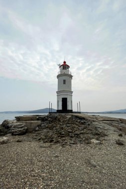 Arkasında dağlar olan güzel yalnız deniz feneri.