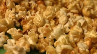 Yeşil arka planda patlamış mısır. Yavaş çekim. Close. Yatay kaydırma. 2 Atış