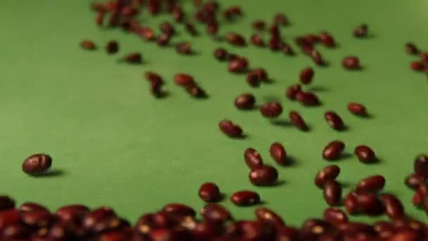 Καστανά φασόλια σε πράσινο φόντο. Αργή κίνηση. Γκρο πλαν. 2 σφηνάκια — Αρχείο Βίντεο