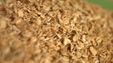 Yeşil bir arka plan üzerinde yulaf ezmesi. Ağır çekim. Yakın çekim. Yatay pan. 2 çekim