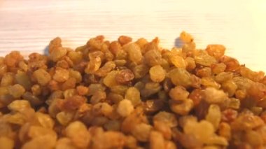 Bej (doku tablo, yüzey) arka plan üzerinde kuru üzüm. 2 Shots.Vertical pan. Yakın çekim.