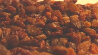 Bej (doku tablo, yüzey) arka plan üzerinde kuru üzüm. 2 Shots.Vertical pan. Yakın çekim.