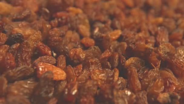 Raisins on a beige (texture table surface) background. 2 Shots. Horizontal pan. Close-up. — Stock Video