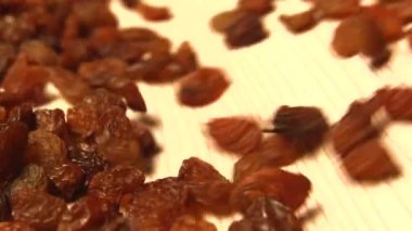 Bej (doku tablo yüzeyi) arka plan üzerinde kuru üzüm. 2 atış. Yavaş çekim. Dikey tava. Close.