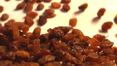 Bej (doku tablo yüzeyi) arka plan üzerinde kuru üzüm. 2 atış. Yavaş çekim. Dikey tava. Close.
