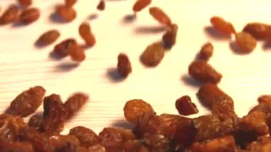 Bej (doku tablo yüzeyi) arka plan üzerinde kuru üzüm. 2 atış. Yavaş çekim. Yatay kaydırma. Close.