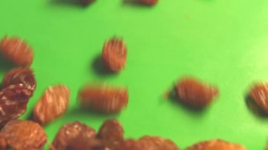 Yeşil arka planda kuru üzüm. 2 atış. Dikey tava. Yavaş çekim. Close.